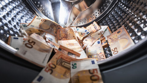 Geldwäschegesetz Mehrere 50 Euro Scheine liegen in einer offenen Waschmaschinentrommel.