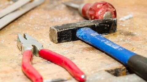 Handwerksrecht Zange und Hammer auf einer Werkbank