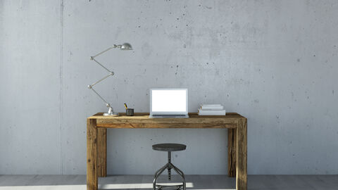 Holzschreibtisch mit Hocker, Schreibtischlampe und Notebook