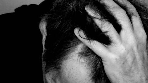 eine Person legt den Kopf in die Hände