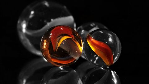 Schwarzer Hintergrund und bunte Murmeln.