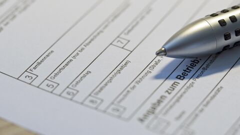 Auf einem Tisch liegendes Antragsformular mit darauf liegendem Kugelschreiber.