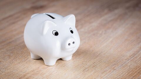 Sparschwein auf Tischplatte stehend.