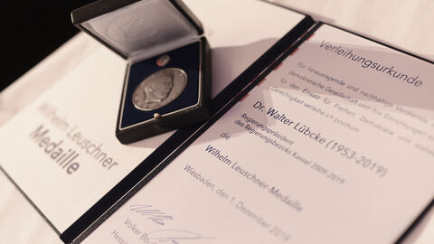 Wilhelm Leuschner-Medaille an Dr. Walter Lübcke Medaille auf einer Urkunde.