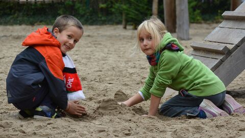 Kinder spielen im Sand