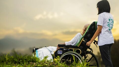 Pflegekraft mit Rollstuhlpatient  Pflegekraft mit Rollstuhlpatient