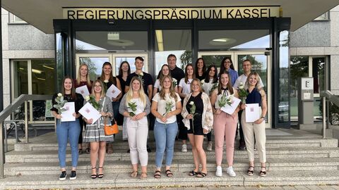 Auszubildende gemeinsam mit Regierungspräsident Mark Weinmeister auf der Treppe vor dem Regierungspräsidium in Kassel.