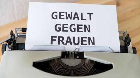Schreibmaschine mit beschriebenem Blatt und dem Text "Gewalt gegen Frauen"