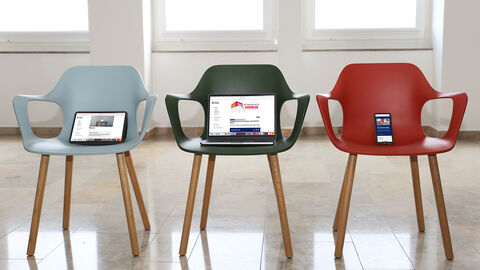 Drei Stühlel nebeneinander mit Tablet, Notebook und Smarkphone darauf. Auf den Displays ist je eine Seite der neuen Website zu sehen.
