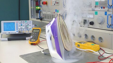 dampfendes Bügeleisen auf Metallplatte