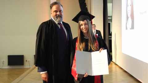 Frau Müller mit Ihrer Abschlussurkunde. 