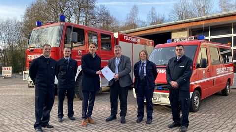 RP Weinmeistre und weitere Personen der Feuerwehr Großalmerode vor Feuerwehrfahrzeugen.