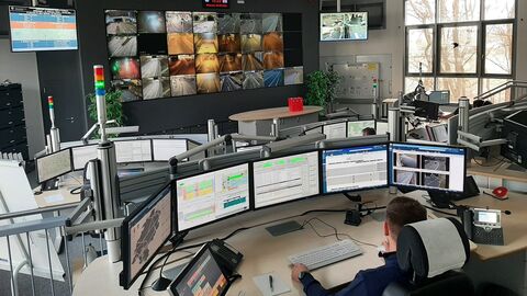 Leitstelle mit vielen Monitoren und einer Person davor, die diese überwacht.