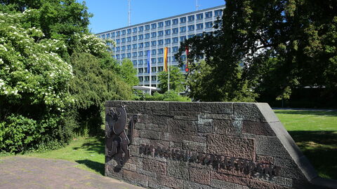 Gebäudeaufnahme des Regierungspräsidiums Kassel. Im Vordergrund befindet sich eine Mauer mit der Aufschrift "Der Regierungspräsident"