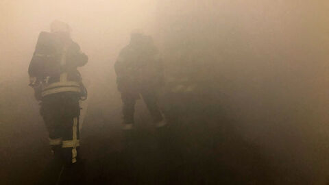 Feuerwehrmänner in dichtem Rauch.