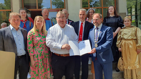 Regierungspräsident überreicht eine Urkunde.