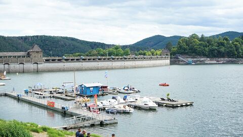 Edersee Staumauer mit Steg und Booten im Vordergrund
