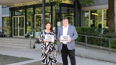 Personalratsvorsitzende Melihat Coskun und Regierungspräsident Mark Weinmeister mit Schildern "Haltung zeigen".
