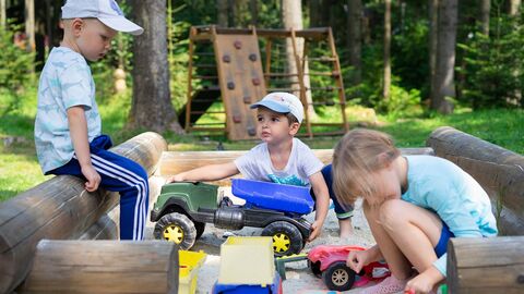 Kita-Assistenz Kinde spielen im Sandkasten
