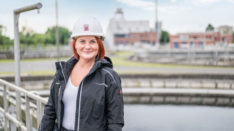 Person auf der Brücke eines Klärbeckens.