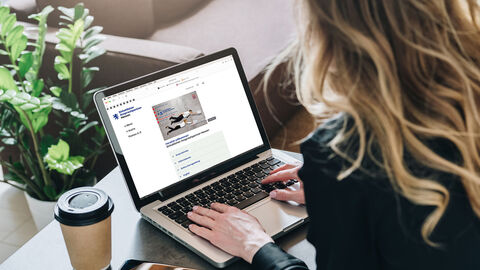 Einheitlicher Ansprechpartner Hessen Frau sitzt vor ihrem Laptop und schaut sich die Seite (Einheitlicher Ansprechpartner Hessen) an