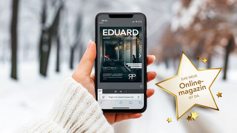 Schneelandschaft in einem Wald im Hintergrund. Frauenarm im weißen Pullover hält ein Handy in der Hand. Zu sehen ist die Titelseite des neuen Onlinemagazins.